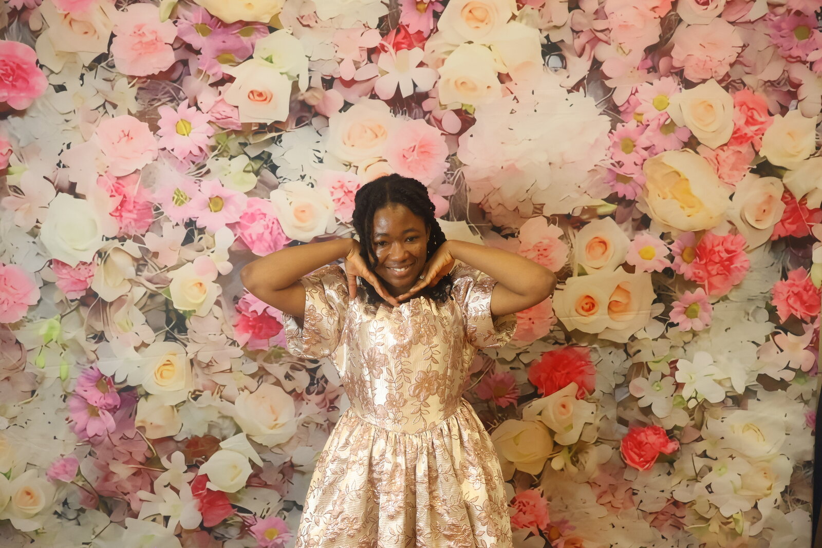 Calgary celebration guest posing solo at the floral photo booth backdrop