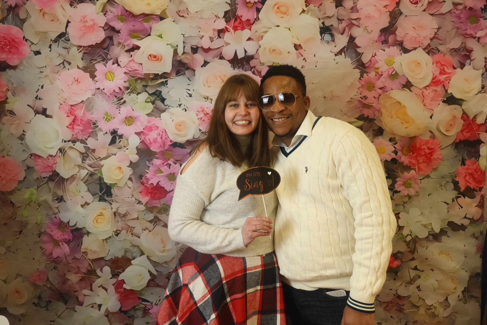 Calgary celebration guests with fun props at the floral photo booth backdrop